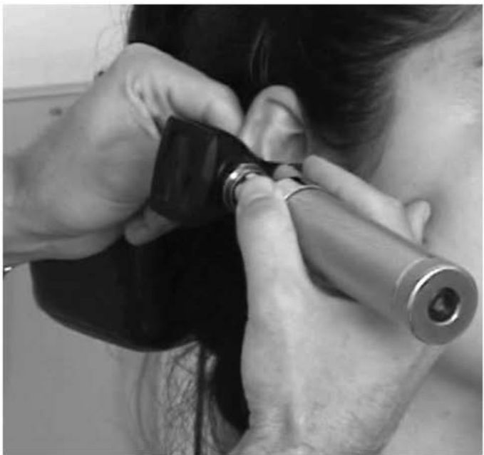 Otoscópio seguro como caneta com a mão apoiada na bochecha